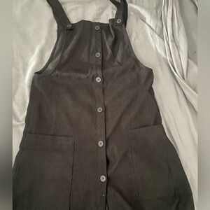 Black dress similar to an overall. Still has every button and almost brand new.